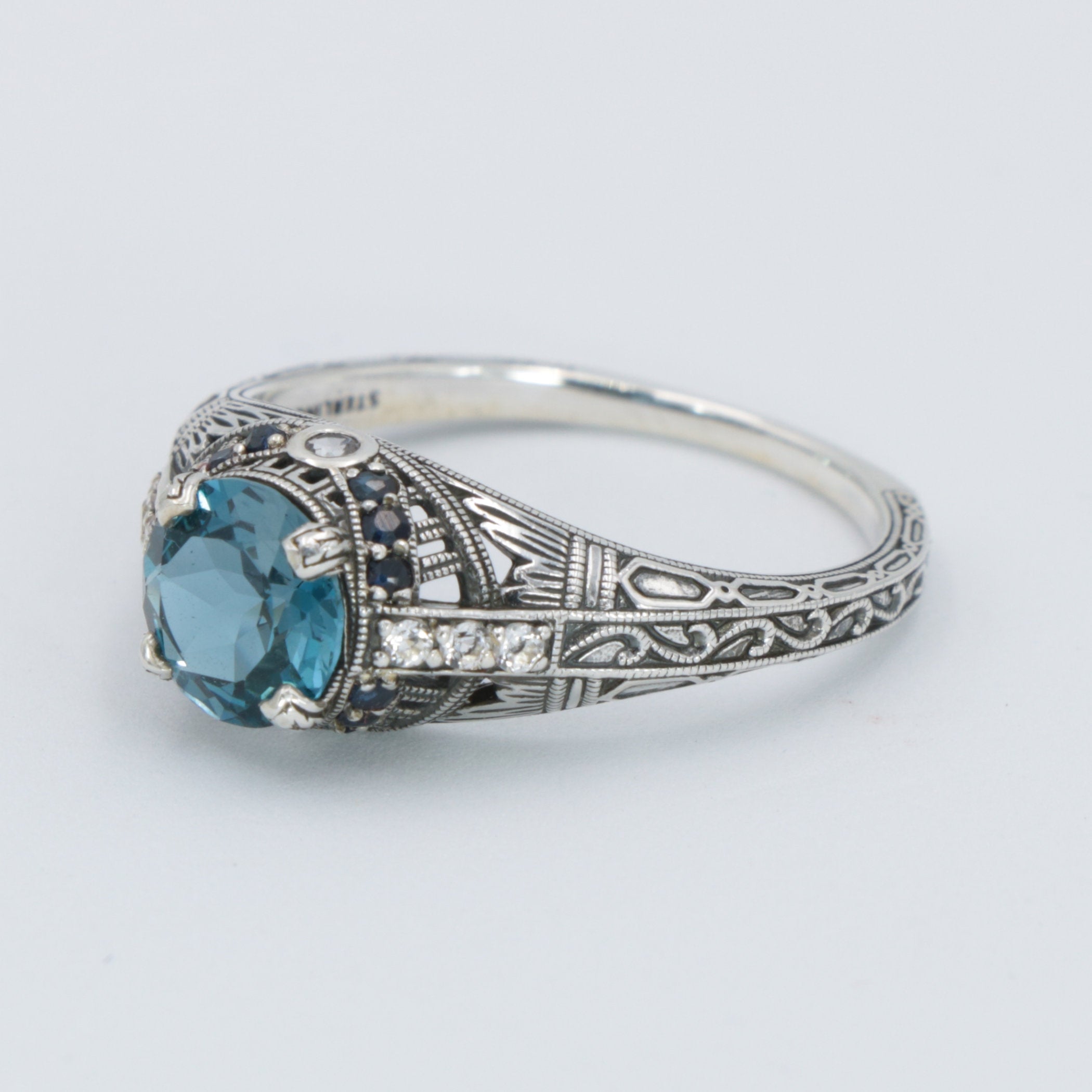 Detail view of Art Deco Style 7mm London Blue Topaz Filigree Ring w/ Sapphire and Topaz accents Sterling Silver highlighting 