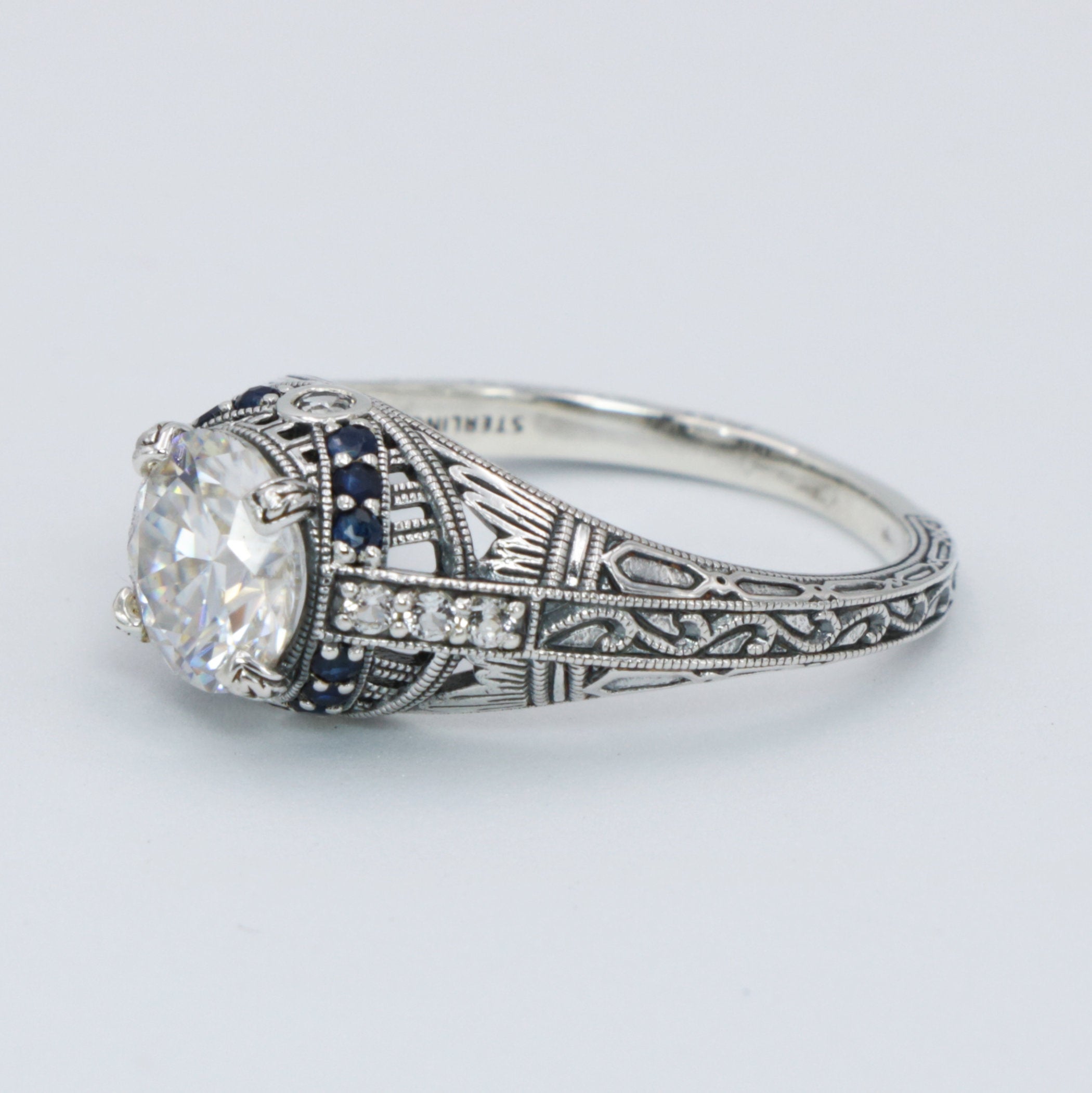 Detail view of Art Deco Style Moissanite Filigree Ring Blue Sapphire and White Topaz Accents Sterling Silver highlighting Whi