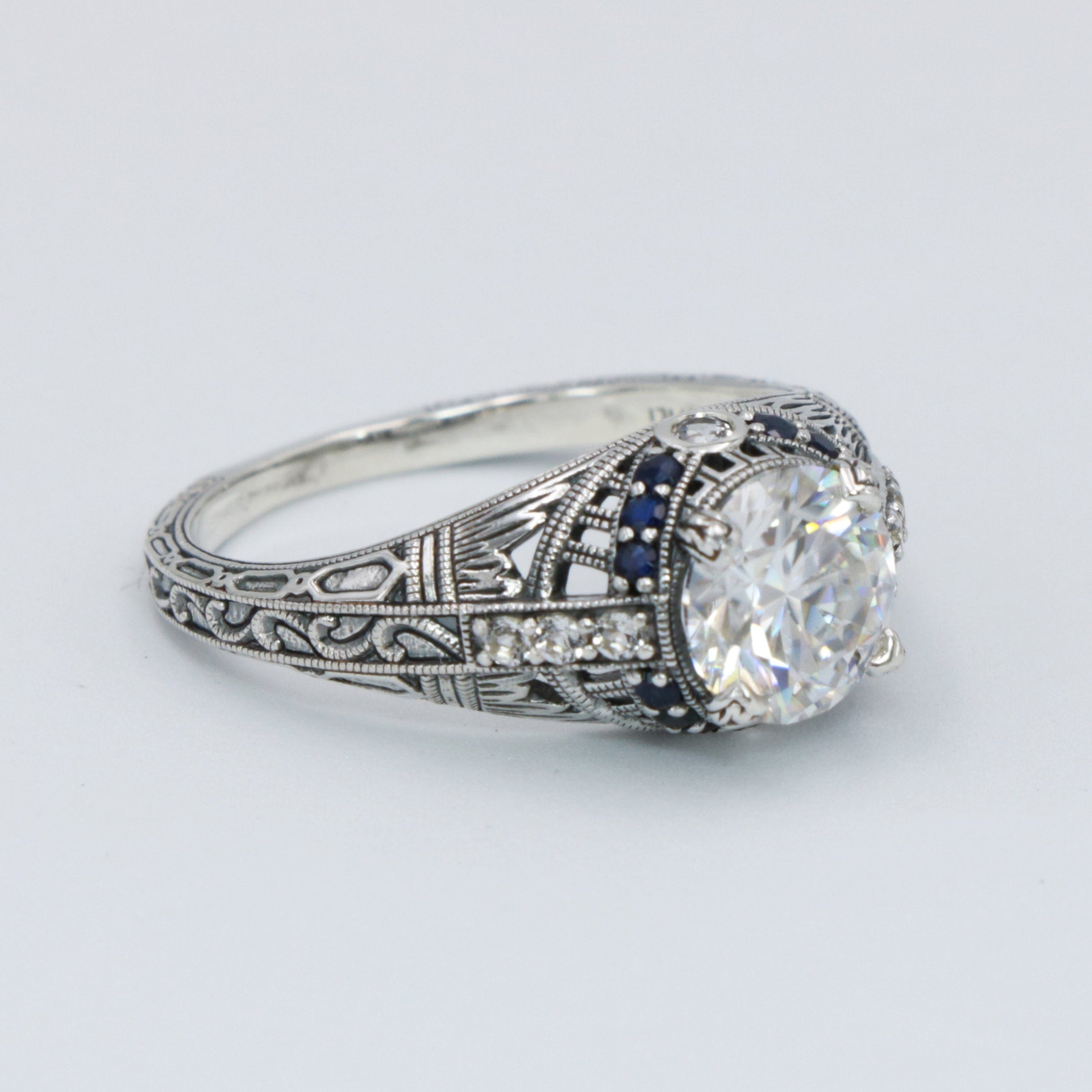 Detail view of Art Deco Style Moissanite Filigree Ring Blue Sapphire and White Topaz Accents Sterling Silver highlighting Whi